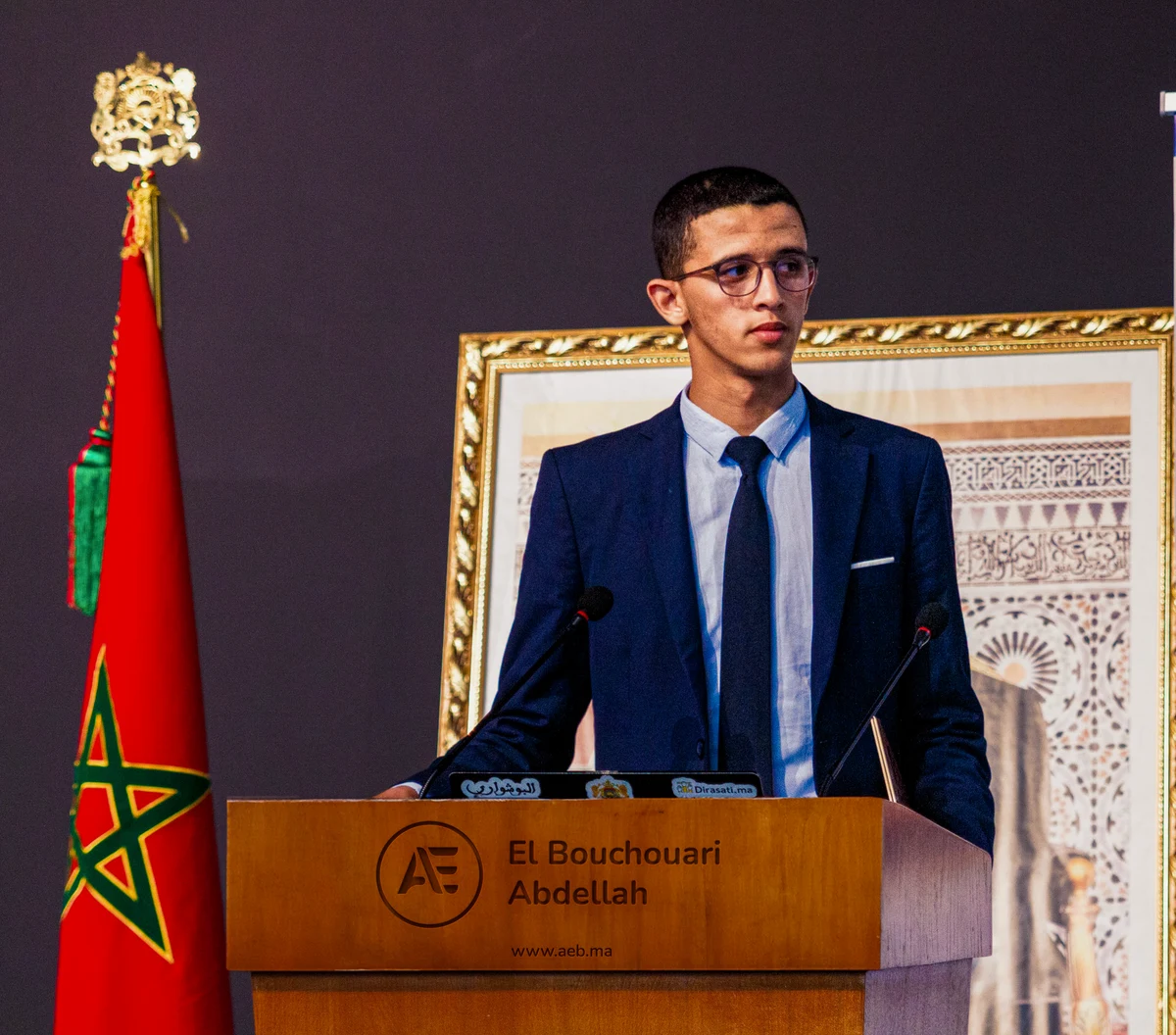Abdellah El Bouchouari speaking at a podium
